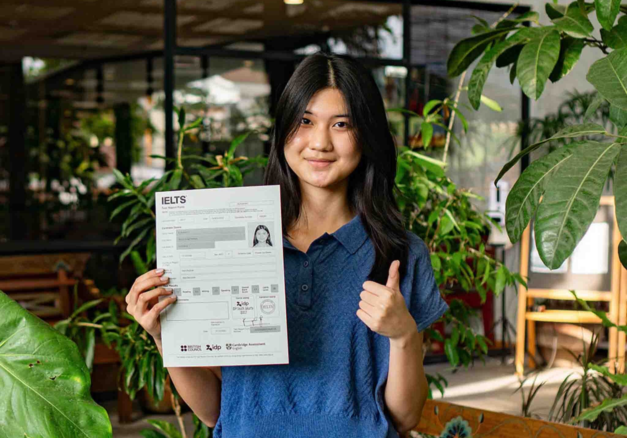 ielc-IELTS-testimonial-student-thumbs-up-holding-IELTS-results
